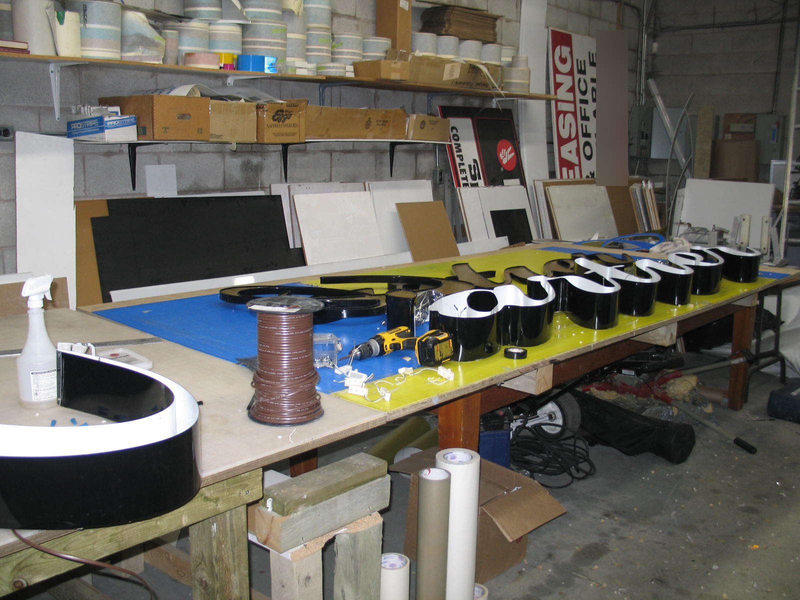Shop bench with channel letters, returns, LED modules and a spool of wire