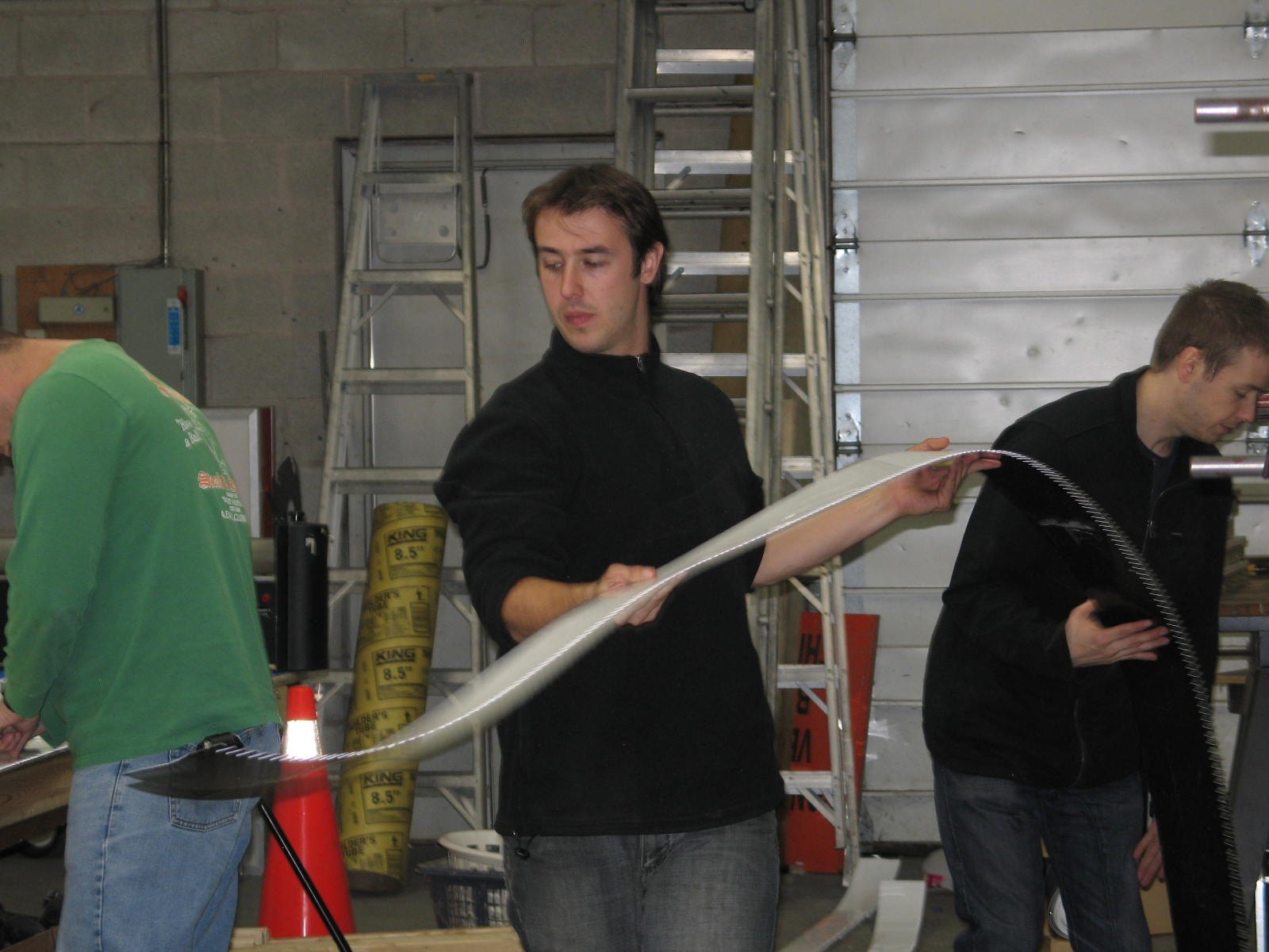 Sign maker forming a channel letter return by hand from a strip of aluminum coil