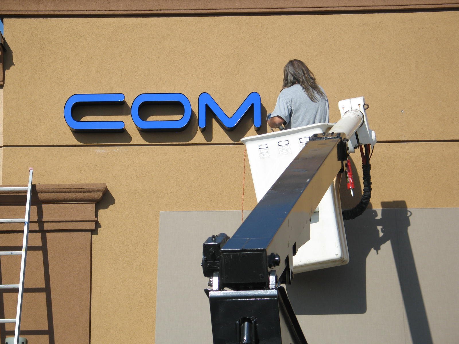Channel letters being installed one at a time from a bucket truck