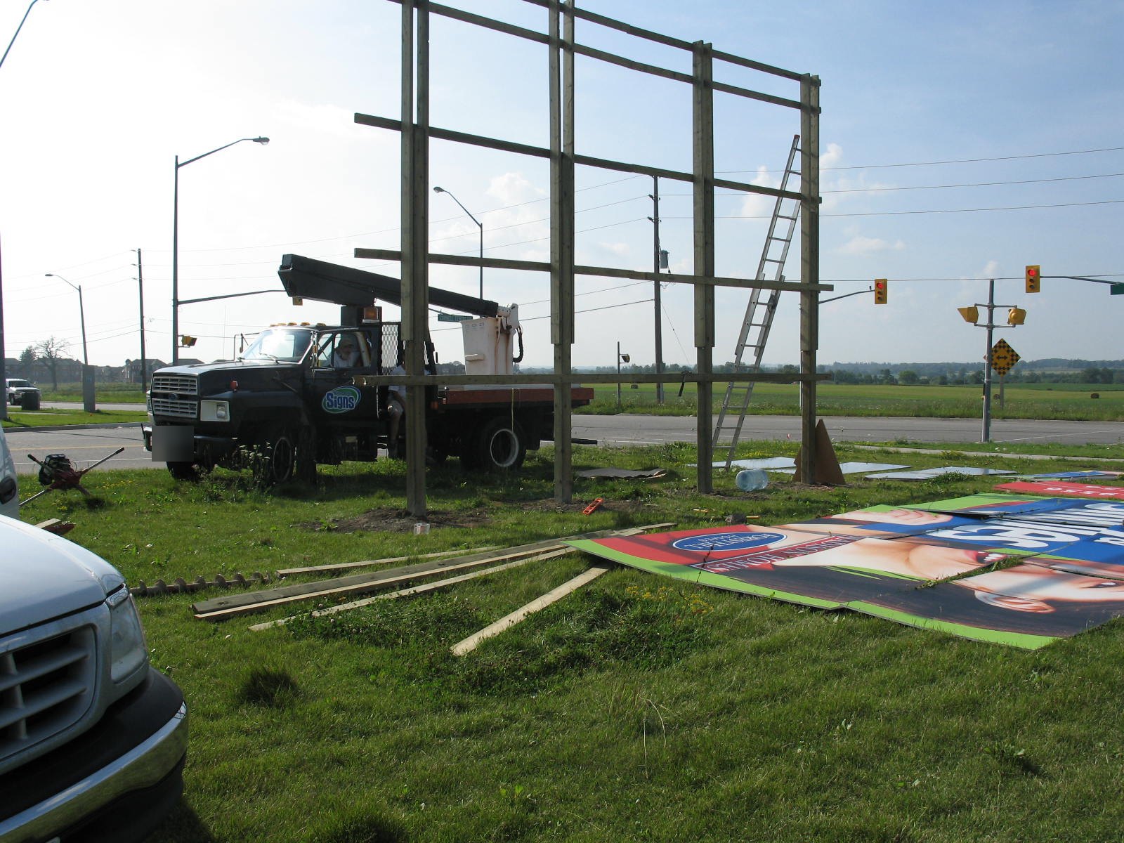 Wooden frame for a large ground sign going up beside a bucket truck